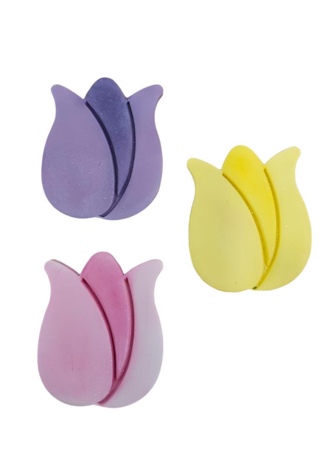 Set of three tulip-shaped icing decorations in pink, purple, and yellow colors.