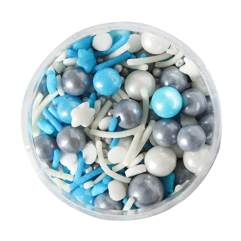 A clear container filled with blue, silver, white, and gray edible baking decorations, including pearls and stars.