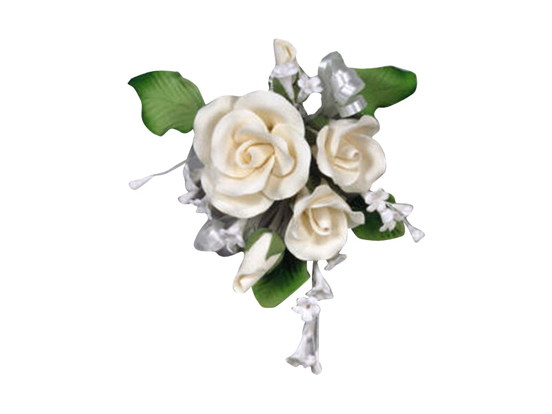 A decorative cake spray with white roses and green leaves, designed to be placed on top of a cake.