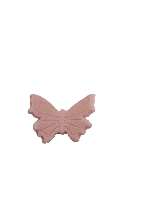 Pink butterfly-shaped object on a white surface