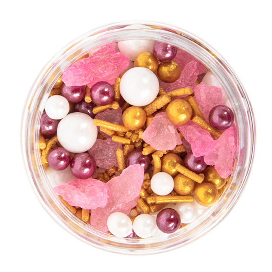 Clear container filled with colorful decorative items including pink and gold elements on a white background