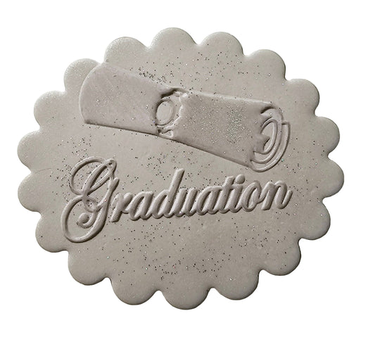 A round silver graduation plaque with graduation writing and a scroll design, suitable for cake decoration.