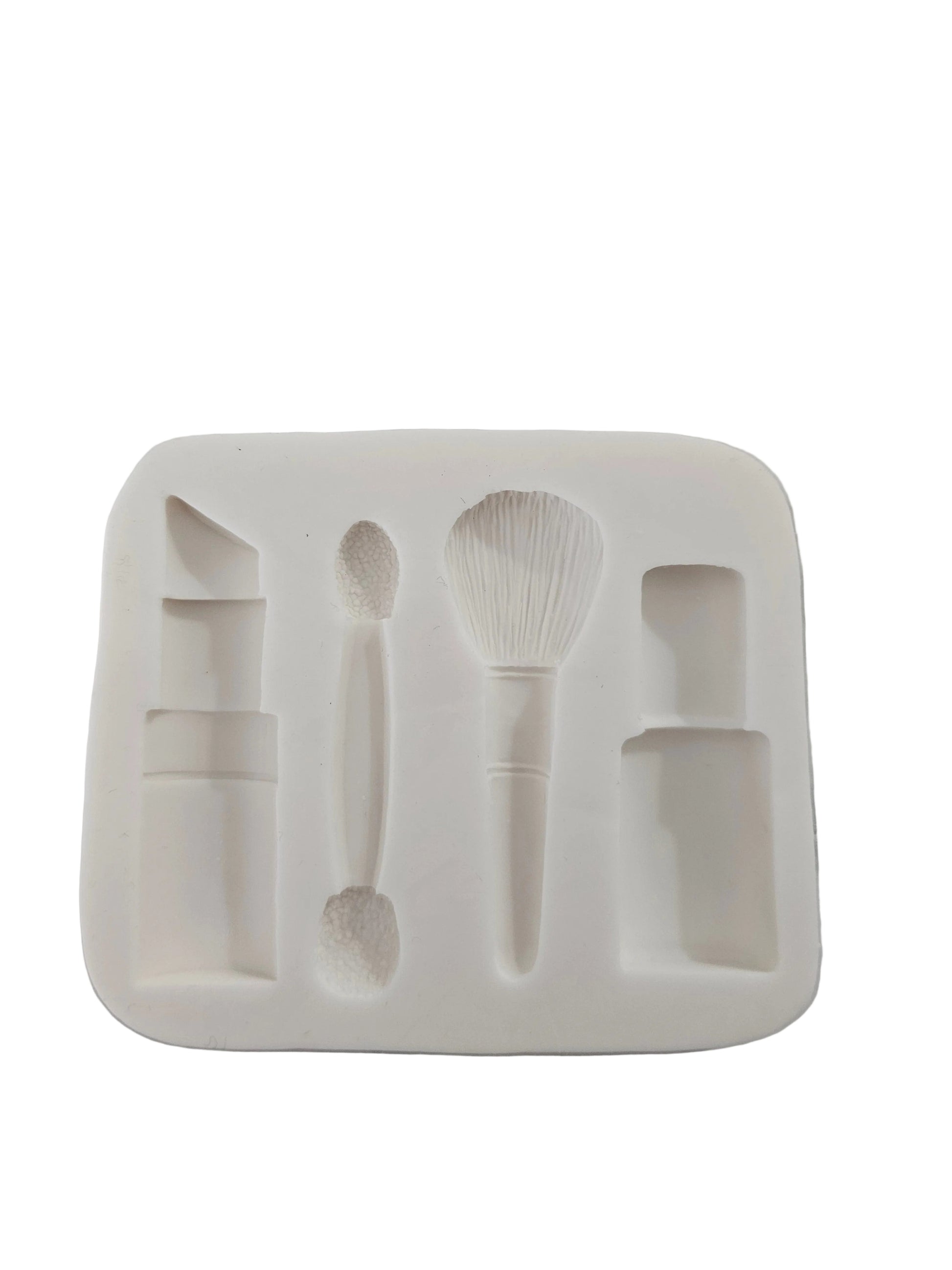 Silicone mould featuring lipstick, brushes, foundation bottle and nail polish cavities for fondant and chocolate decorations.
