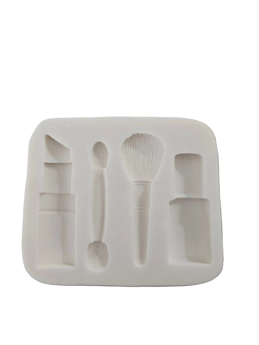 Silicone mould featuring lipstick, brushes, foundation bottle and nail polish cavities for fondant and chocolate decorations.