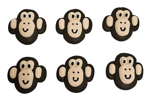 Six monkey-shape made out of Royal Icing on a white surface