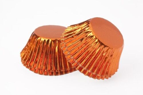 Two orange foil cupcake cases with a shiny surface and textured edges, designed for holding cupcakes.