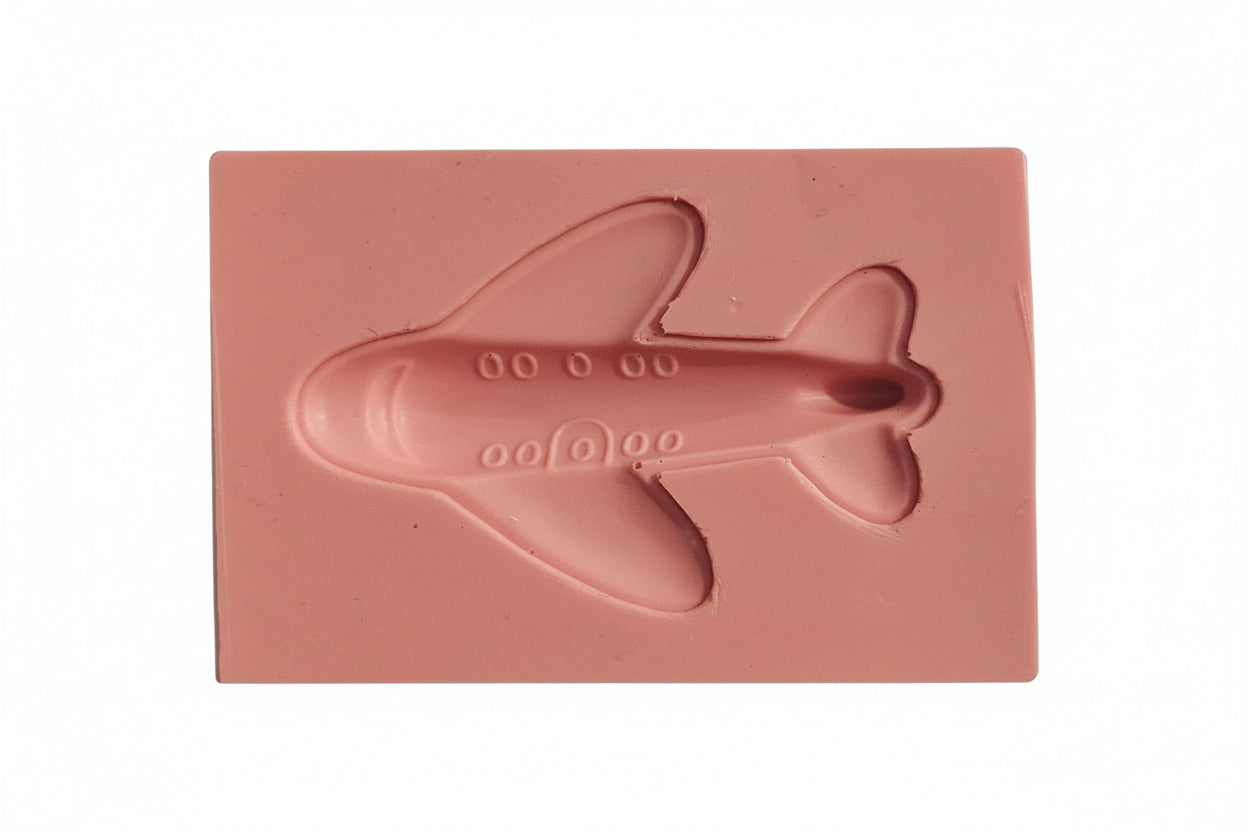 Small plane-shaped silicone mould in food-safe flexible silicone, showing detailed cavities for fondant and chocolate toppers