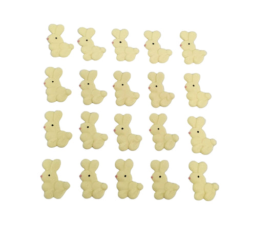 Yellow bunny-shaped made out of royal icing on a white background