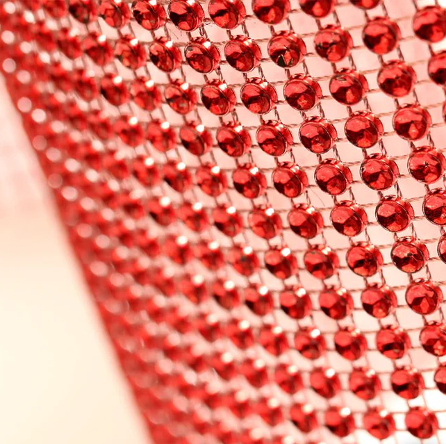 Red glam ribbon with concaved stone shapes that create a diamond‑illusion sparkle. Non‑edible decorative ribbon for cakes and event décor.