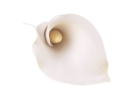 A white gum paste flower with a yellow-colored center, designed to resemble a calla or arum lily.