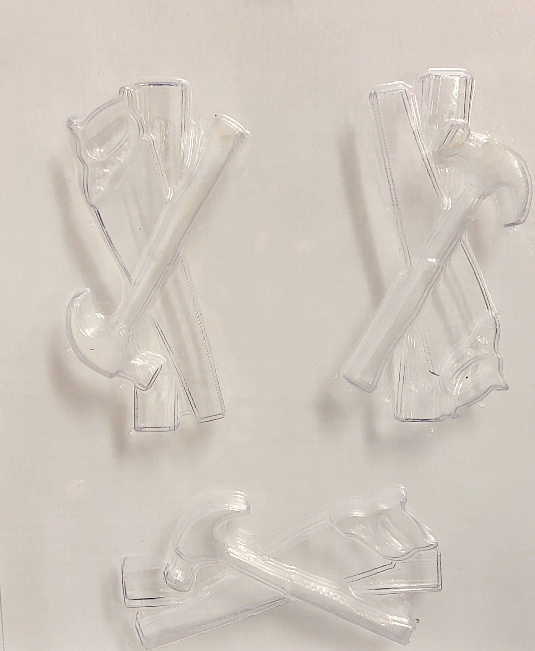 A clear chocolate mould tool set with various components, including a hammer, spirit leveler, and hand wood saw, designed for cake decorating.