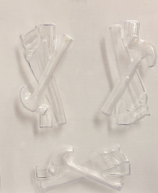 A clear chocolate mould tool set with various components, including a hammer, spirit leveler, and hand wood saw, designed for cake decorating.