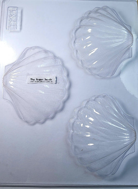 Three clear chocolate moulds in the shape of clam shells, displayed on a white background.