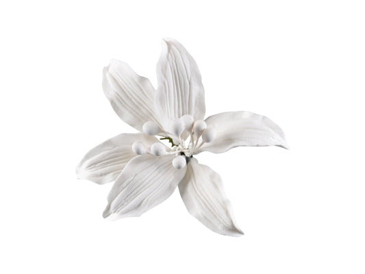 A small, white, wired petal cake decoration designed to resemble a lily, with stamens in the center.
