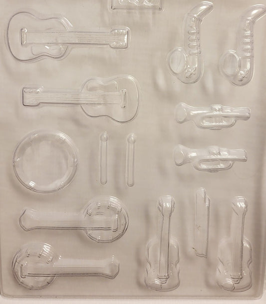 A set of clear plastic molds in the shapes of various music instruments, including a drum, banjo, violin, sax, trumpet, and guitar.
