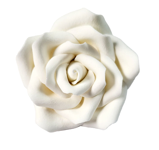 A white icing flower designed to resemble a rose, used for cake decorating.