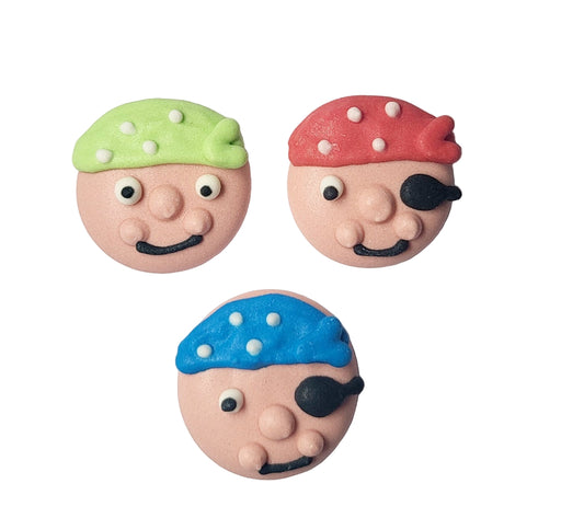 Three colorful royal icing cookie cutters in the shapes of pirate faces with different color accents, including green, red, and blue, designed to fit onto cupcakes or larger cakes.